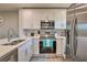 Modern kitchen features stainless steel appliances, white cabinetry, and stylish backsplash at 3282 Mangrove Point Dr, Ruskin, FL 33570