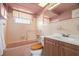 Charming bathroom features a tub with shower, vanity, and unique pink and wood accents at 3348 Clydesdale Dr, Holiday, FL 34691