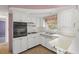Bright kitchen equipped with white cabinets, modern appliances, and tiled flooring at 3348 Clydesdale Dr, Holiday, FL 34691