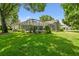 Expansive backyard with lush green lawn and screened-in patio with pool at 3351 Bristol Pl, Tarpon Springs, FL 34688