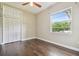 Bright bedroom featuring a window, closet, ceiling fan and hardwood floors at 3351 Bristol Pl, Tarpon Springs, FL 34688