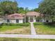 Stunning single-story home featuring mature landscaping, a beautiful tile roof, and a welcoming entryway at 3351 Bristol Pl, Tarpon Springs, FL 34688