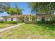 Beautiful single-story home featuring arched windows, a tile roof, and manicured landscaping at 3351 Bristol Pl, Tarpon Springs, FL 34688
