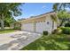 Spacious three-car garage with white doors, providing ample parking and storage space at 3351 Bristol Pl, Tarpon Springs, FL 34688
