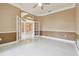 Open living area featuring white tile floors, tan walls, modern ceiling fan, and french doors at 3351 Bristol Pl, Tarpon Springs, FL 34688
