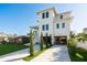 Bright, three-story house with a long driveway and a tidy lawn, showcasing modern architecture at 3752 Arkansas Ne Ave, St Petersburg, FL 33703
