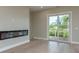 Contemporary living room featuring a modern fireplace, light wood floors, and expansive glass sliding doors at 3752 Arkansas Ne Ave, St Petersburg, FL 33703
