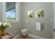 Stylish powder room featuring a wall-mounted toilet, gold accents, and a decorative floral arrangement at 3752 Arkansas Ne Ave, St Petersburg, FL 33703
