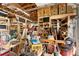 View of cluttered garage featuring ample storage shelves, wood-beam ceiling, and concrete flooring at 39252 Kimberly Ave, Zephyrhills, FL 33540