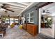 View of covered porch with brick flooring and view to the interior with ceiling fans and storage at 39252 Kimberly Ave, Zephyrhills, FL 33540