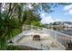 Backyard patio with waterfront view, fire pit, outdoor seating, and lush tropical landscaping at 4315 Flexer Dr, Hernando Beach, FL 34607