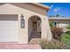 Close-up of the home's front entrance with a charming archway, stucco siding, and a decorative number plate at 4315 Flexer Dr, Hernando Beach, FL 34607