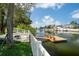 Waterfront backyard featuring a private dock with seating, a white picket fence, and lush landscaping at 4315 Flexer Dr, Hernando Beach, FL 34607