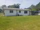 Green backyard featuring a single story home and screened in patio at 4409 W Wyoming Ave, Tampa, FL 33616