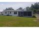Spacious backyard featuring a screened in patio, green lawn and fence at 4409 W Wyoming Ave, Tampa, FL 33616