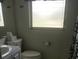 Bathroom featuring a toilet, vanity, and frosted window at 4409 W Wyoming Ave, Tampa, FL 33616