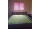 Simple bedroom featuring a full size bed with green covers and a wooden headboard at 4409 W Wyoming Ave, Tampa, FL 33616