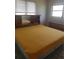 Cozy bedroom featuring natural light, a bed with yellow cover, and a vintage headboard with mirrored storage at 4409 W Wyoming Ave, Tampa, FL 33616