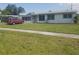 Charming single-story home with a well-maintained lawn and red van parked in the driveway at 4409 W Wyoming Ave, Tampa, FL 33616