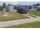 Single-story home with a well-maintained lawn, sidewalk, and red van parked in the driveway at 4409 W Wyoming Ave, Tampa, FL 33616