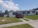 Single-story home with a well-maintained lawn, sidewalk, and red van parked in the driveway at 4409 W Wyoming Ave, Tampa, FL 33616