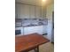 Well-lit kitchen with classic white cabinets, appliances, and a table with seating for casual dining at 4409 W Wyoming Ave, Tampa, FL 33616