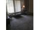 Cozy living room with neutral-toned carpet, blinds, lamp, coffee table, and occasional chair at 4409 W Wyoming Ave, Tampa, FL 33616