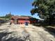 View of the house's backyard with concrete area, grass, and a large tree at 4419 Atwood Dr, Tampa, FL 33610