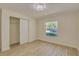 Sunlit bedroom showcasing wood-look tile floor, chandelier, and window overlooking the neighborhood at 4700 Chancellor Ne St, St Petersburg, FL 33703