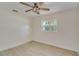 Bedroom features wood-look tile floor, ceiling fan and a large window overlooking the neighborhood at 4700 Chancellor Ne St, St Petersburg, FL 33703