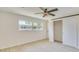 Bright bedroom featuring wood-look tile floor, ceiling fan, a window overlooking the neighborhood, and sliding closet door at 4700 Chancellor Ne St, St Petersburg, FL 33703