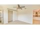Bedroom with wood-look tile floor, ceiling fan and sliding closet door adjacent to en-suite bathroom and kitchen at 4700 Chancellor Ne St, St Petersburg, FL 33703