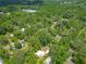 Expansive aerial view of a property nestled among lush green trees in a serene, wooded neighborhood at 473 Forest Ave, Brooksville, FL 34601