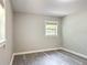 This bedroom features gray walls, grey vinyl floors, a window, and modern trim at 473 Forest Ave, Brooksville, FL 34601