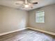 This bedroom features a ceiling fan, grey walls, grey vinyl floors, and a window at 473 Forest Ave, Brooksville, FL 34601