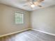 This bedroom features a ceiling fan, grey walls, grey vinyl floors, and a window at 473 Forest Ave, Brooksville, FL 34601