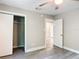This bedroom features a ceiling fan, grey walls, grey vinyl floors, and a closet at 473 Forest Ave, Brooksville, FL 34601