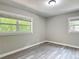 This bedroom features two windows, grey walls, grey vinyl floors, and modern trim at 473 Forest Ave, Brooksville, FL 34601