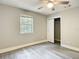 This bedroom features a ceiling fan, grey walls, grey vinyl floors, a window, and a closet at 473 Forest Ave, Brooksville, FL 34601
