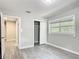 This bedroom features gray walls, grey vinyl floors, a window, and a closet at 473 Forest Ave, Brooksville, FL 34601