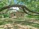 A house is partially hidden beneath the branches of a huge oak in the yard at 473 Forest Ave, Brooksville, FL 34601