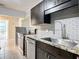 Modern kitchen with stainless steel appliances, granite countertops, dark cabinets, and stylish gray backsplash at 473 Forest Ave, Brooksville, FL 34601