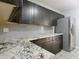 Modern kitchen featuring granite counters, stylish dark cabinets, stainless steel appliances, and a gray backsplash at 473 Forest Ave, Brooksville, FL 34601