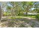 Large, partially shaded backyard with mature trees, offering a serene and private outdoor space at 4805 E Regnas Ave, Tampa, FL 33617