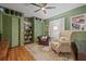 Comfortable green bedroom with hardwood floors, multiple closets and a ceiling fan at 4805 E Regnas Ave, Tampa, FL 33617