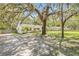 Quaint home exterior with mature trees, landscaping, and a long driveway leading to the property at 4805 E Regnas Ave, Tampa, FL 33617