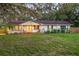 Charming single-story home with manicured lawn, inviting front porch, and mature trees at 4805 E Regnas Ave, Tampa, FL 33617