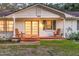 Inviting front porch with red tile, cozy chairs, and warm lighting, perfect for relaxing and enjoying the outdoors at 4805 E Regnas Ave, Tampa, FL 33617