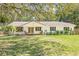 Charming single-story home with a well-manicured lawn and mature trees providing ample shade at 4805 E Regnas Ave, Tampa, FL 33617