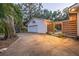 Detached one-car garage with basketball hoop on a concrete driveway and wooden privacy fence at dusk at 4805 E Regnas Ave, Tampa, FL 33617